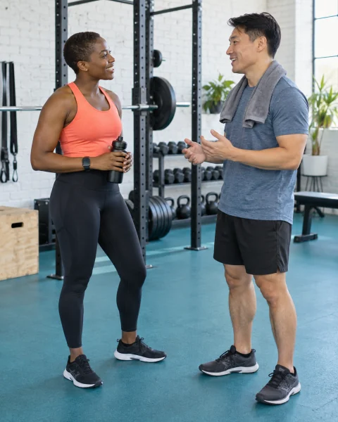 A personal trainer listening to a client in an independent fitness studio.